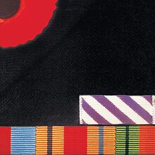 A close up of the breast a dark jacket, with one quarter of a remembrance poppy on the top left corner, and a selection of British military service medal ribbons along the bottom edge